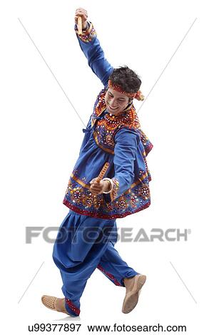 Stock Photo - Happy young man in traditional wear performing Dandiya Rass over white background. Fotosearch