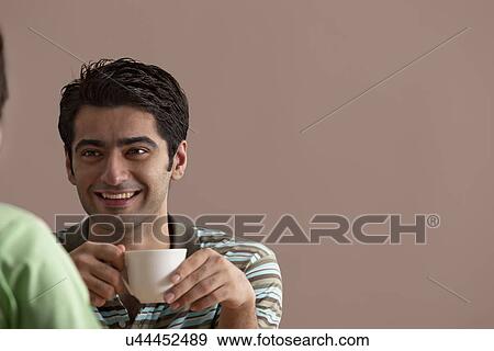 Stock Photo - Happy young man on coffee date with woman . Fotosearch