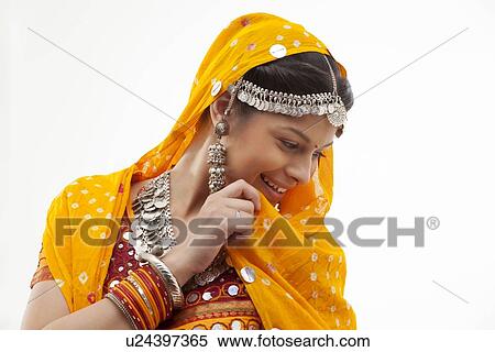 Happy young shy woman in traditional wear looking down isolated over white background View Large Photo Image Stock Photography - Happy young shy woman in traditional wear looking down isolated over white background. Fotosearch