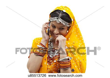 Happy young shy woman using mobile phone over white background View Large Photo Image Stock Photograph - Happy young shy woman using mobile phone over white background. Fotosearch