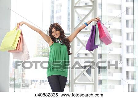 Happy young woman carrying shopping bags View Large Photo Image Stock Photography - Happy young woman carrying shopping bags . Fotosearch