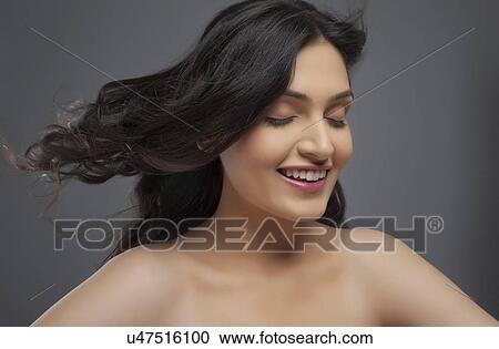 Happy young woman enjoying the breeze over colored background View Large Photo Image Stock Image - Happy young woman enjoying the breeze over colored background . Fotosearch
