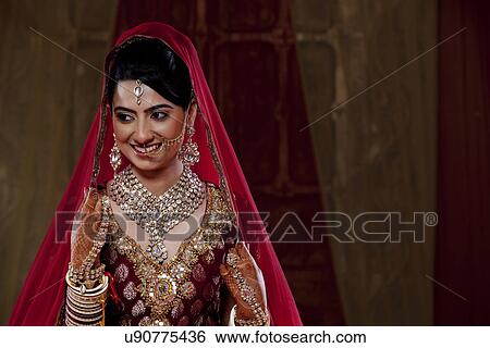 Indian bride in traditional clothing and jewelry View Large Photo Image Stock Photograph - Indian bride in traditional clothing and jewelry . Fotosearch