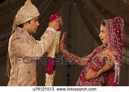 Stock Image - Indian bride rejecting a groom with a garland . Fotosearch