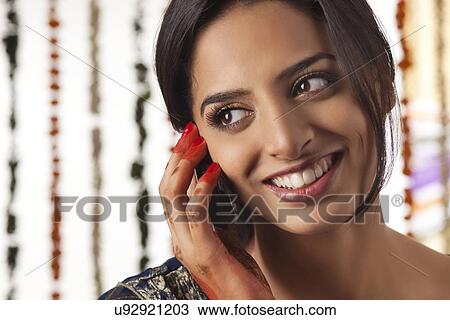 Stock Image - Indian bride talking on a mobile phone . Fotosearch