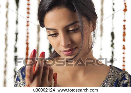 Indian bride wearing bangles View Large Photo Image Picture - Indian bride wearing bangles . Fotosearch