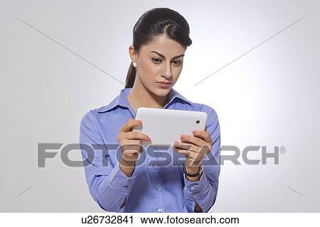 Indian businesswoman using digital tablet against gray background View Large Photo Image Stock Image - Indian businesswoman using digital tablet against gray background. Fotosearch