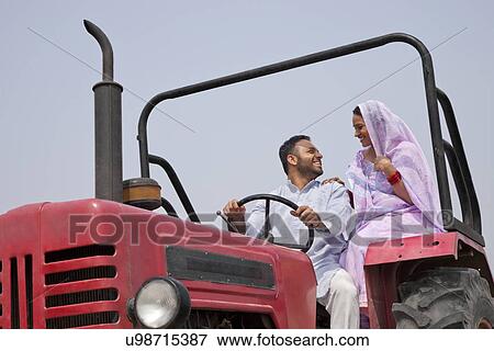 Indian couple looking at each other while sitting in a tractor View Large Photo Image Stock Photo - Indian couple looking at each other while sitting in a tractor . Fotosearch