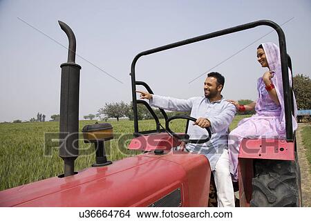 Indian couple on tractor with man pointing at something View Large Photo Image Picture - Indian couple on tractor with man pointing at something . Fotosearch