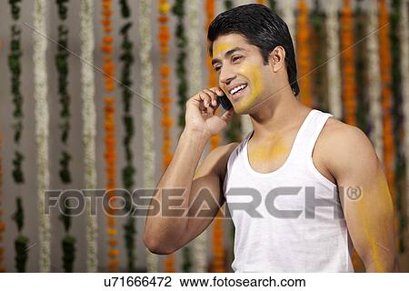 Indian groom talking on a mobile phone View Large Photo Image Stock Image - Indian groom talking on a mobile phone . Fotosearch