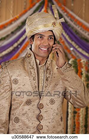 Stock Photo - Indian groom talking on a mobile phone . Fotosearch