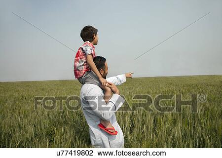 Indian man pointing at something while carrying son on shoulders View Large Photo Image Stock Image - Indian man pointing at something while carrying son on shoulders . Fotosearch