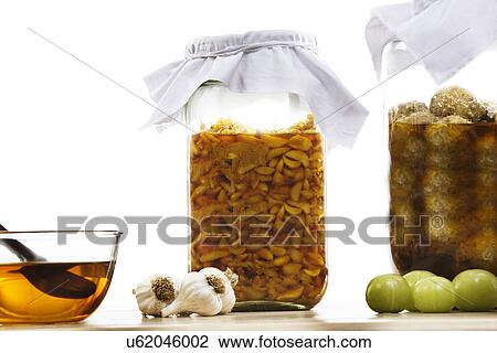 Stock Image - Jars filled with garlic and gooseberry pickle . Fotosearch