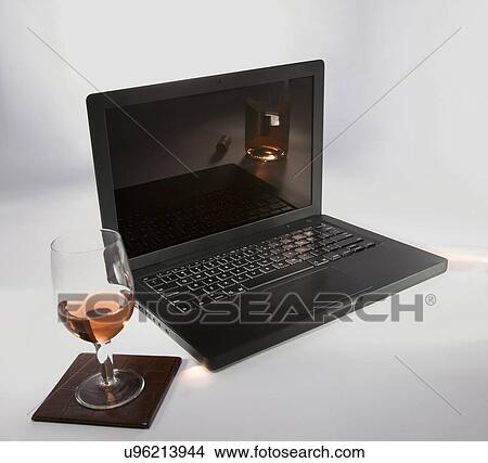 Picture - Laptop and a glass of wine . Fotosearch