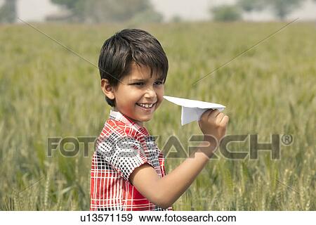 Little boy holding a paper aeroplane View Large Photo Image Stock Photo - Little boy holding a paper aeroplane . Fotosearch
