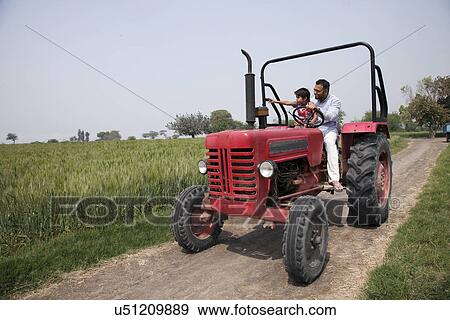 Little boy showing something to father while sitting in tractor View Large Photo Image Stock Photo - Little boy showing something to father while sitting in tractor . Fotosearch