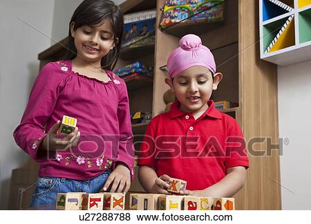 Little brother and sister playing with wooden toy blocks View Large Photo Image Stock Photo - Little brother and sister playing with wooden toy blocks . Fotosearch