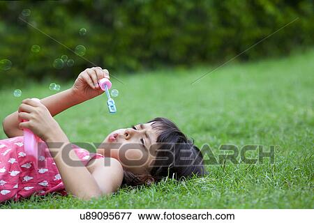 Little girl blowing bubbles View Large Photo Image Stock Photo - Little girl blowing bubbles . Fotosearch