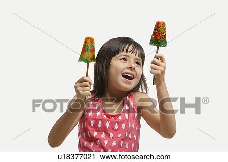 Little girl holding two ice lollies View Large Photo Image Stock Image - Little girl holding two ice lollies . Fotosearch