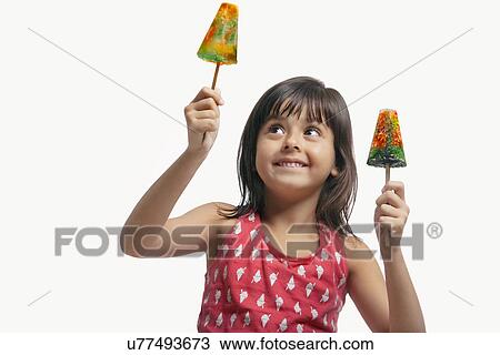 Little girl holding two ice lollies View Large Photo Image Stock Image - Little girl holding two ice lollies . Fotosearch