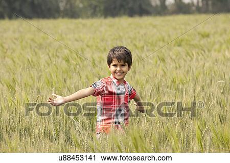 Little Indian boy standing in a wheat field with arms out View Large Photo Image Stock Image - Little Indian boy standing in a wheat field with arms out . Fotosearch