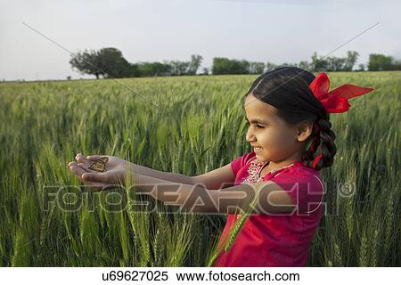 Little rural girl with hands cupped standing in a wheat field View Large Photo Image Stock Photography - Little rural girl with hands cupped standing in a wheat field . Fotosearch