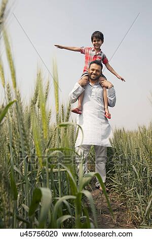 Low angle view of a happy father carrying son on shoulders View Large Photo Image Stock Image - Low angle view of a happy father carrying son on shoulders . Fotosearch