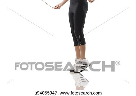 Low section of a woman skipping over white background View Large Photo Image Stock Photo - Low section of a woman skipping over white background . Fotosearch