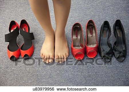 Low section of woman standing barefoot with sandals View Large Photo Image Stock Photograph - Low section of woman standing barefoot with sandals . Fotosearch