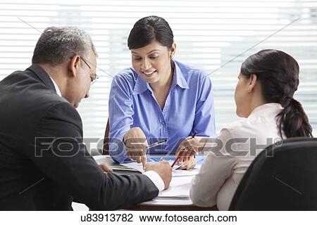 Stock Image - Male and female professionals discussing in meeting . Fotosearch