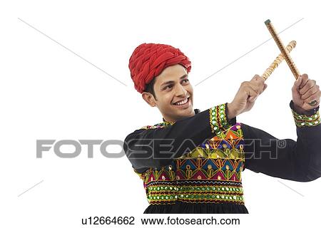 Male dandiya dancer dancing with sticks View Large Photo Image Stock Image - Male dandiya dancer dancing with sticks . Fotosearch