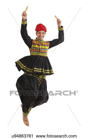 Male dandiya dancer dancing with sticks View Large Photo Image Stock Image - Male dandiya dancer dancing with sticks . Fotosearch