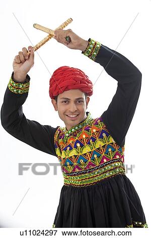 Male dandiya dancer dancing with sticks View Large Photo Image Stock Photo - Male dandiya dancer dancing with sticks . Fotosearch