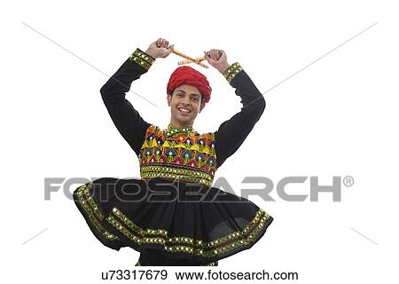 Stock Photo - Male dandiya dancer dancing with sticks . Fotosearch