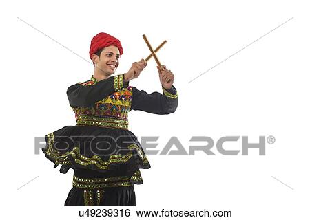 Male dandiya dancer dancing with sticks View Large Photo Image Stock Photograph - Male dandiya dancer dancing with sticks . Fotosearch