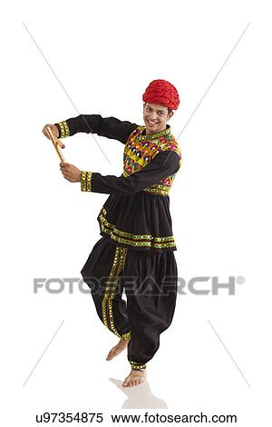 Stock Photography - Male dandiya dancer dancing with sticks . Fotosearch