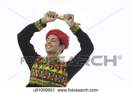 Male dandiya dancer listening to music and dancing View Large Photo Image Stock Image - Male dandiya dancer listening to music and dancing . Fotosearch