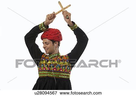 Stock Photo - Male dandiya dancer listening to music and dancing . Fotosearch