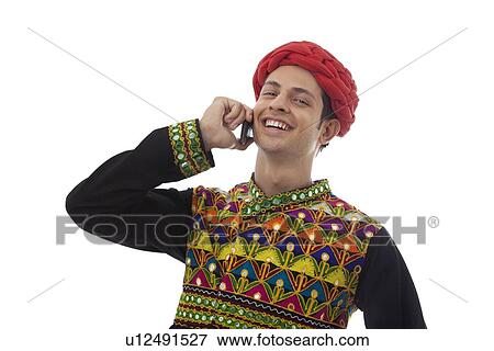 Stock Photo - Male dandiya dancer talking on a mobile phone . Fotosearch