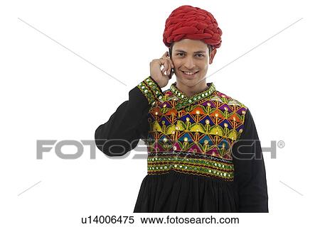 Stock Photography - Male dandiya dancer talking on a mobile phone . Fotosearch