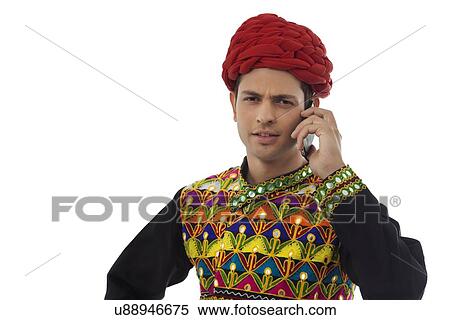 Male dandiya dancer talking on a mobile phone View Large Photo Image Stock Photography - Male dandiya dancer talking on a mobile phone . Fotosearch