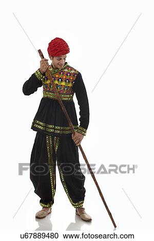 Stock Image - Male dandiya dancer with a stick . Fotosearch