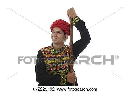 Stock Image - Male dandiya dancer with a stick . Fotosearch