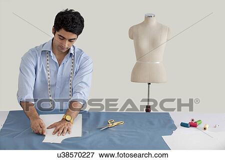 Stock Photo - Male fashion designer working in fashion studio . Fotosearch