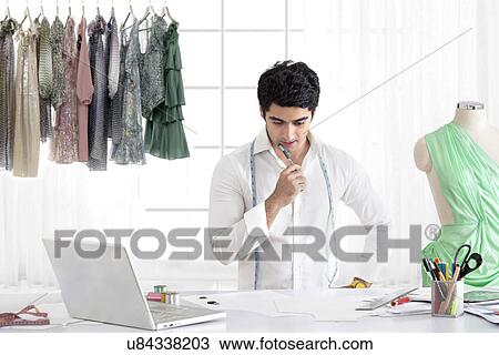 Stock Image - Male fashion designer working in studio . Fotosearch