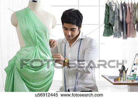 Stock Photography - Male fashion designer working in studio . Fotosearch