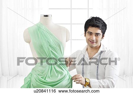 Male fashion designer working on dressmaker's form View Large Photo Image Stock Photograph - Male fashion designer working on dressmaker's form . Fotosearch