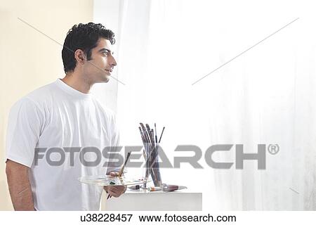 Male painter holding paint palette and brush View Large Photo Image Stock Photo - Male painter holding paint palette and brush . Fotosearch