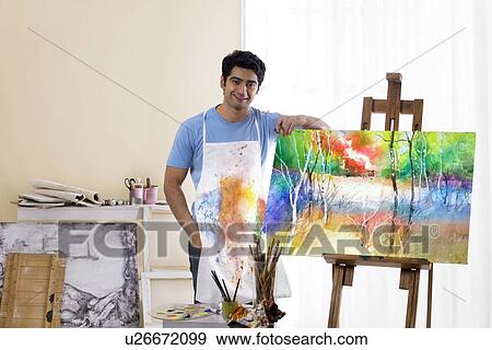 Male painter standing in front of painted canvas View Large Photo Image Stock Photo - Male painter standing in front of painted canvas . Fotosearch