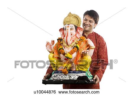 Man carrying a Ganesh idol View Large Photo Image Stock Photograph - Man carrying a Ganesh idol . Fotosearch